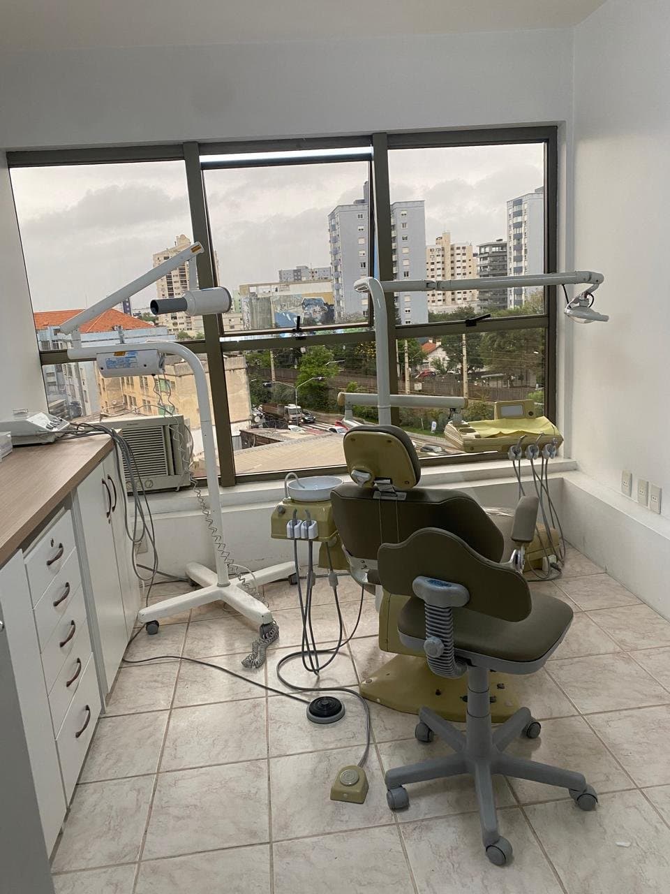 Sala de atendimento com cadeira odontológica e vista da cidade