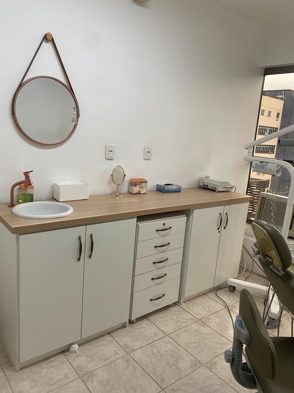 Bancada clínica organizada com equipamentos de odontologia